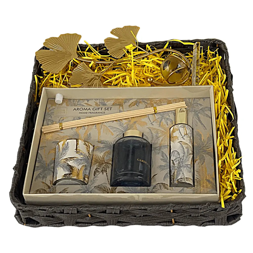 Aroma gift set with candles and diffuser in a decorative box with gold leaves and straw.