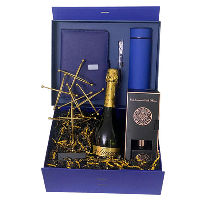 Gift set with champagne bottle, blue tumbler, and other items in a blue box.