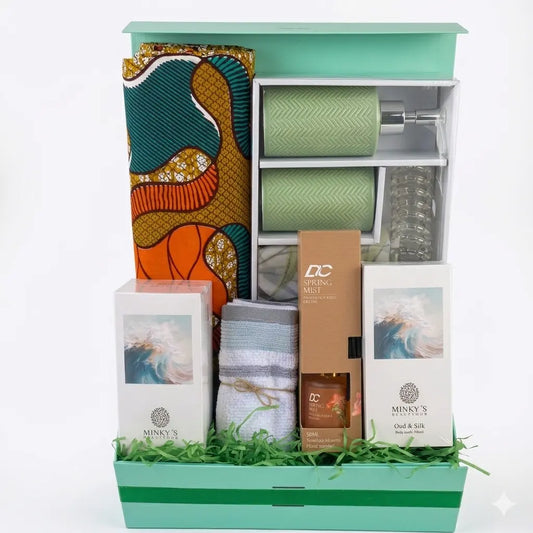 Gift basket with various items including a patterned fabric, stationery, and small boxes on a white background.