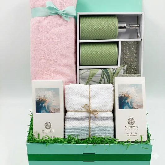 Gift basket with towels, a bottle, and books on a white background