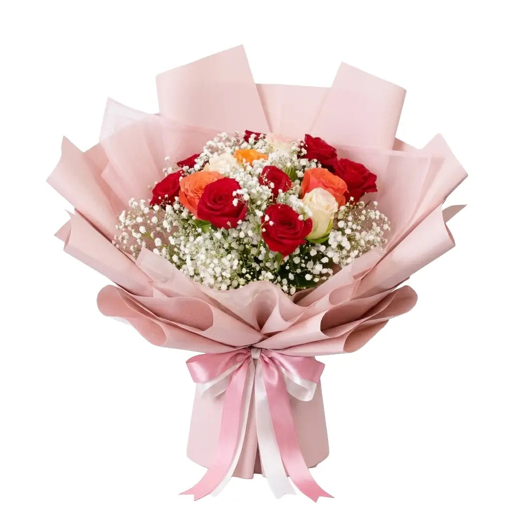Bouquet of red and orange flowers wrapped in pink paper with a pink ribbon on a white background