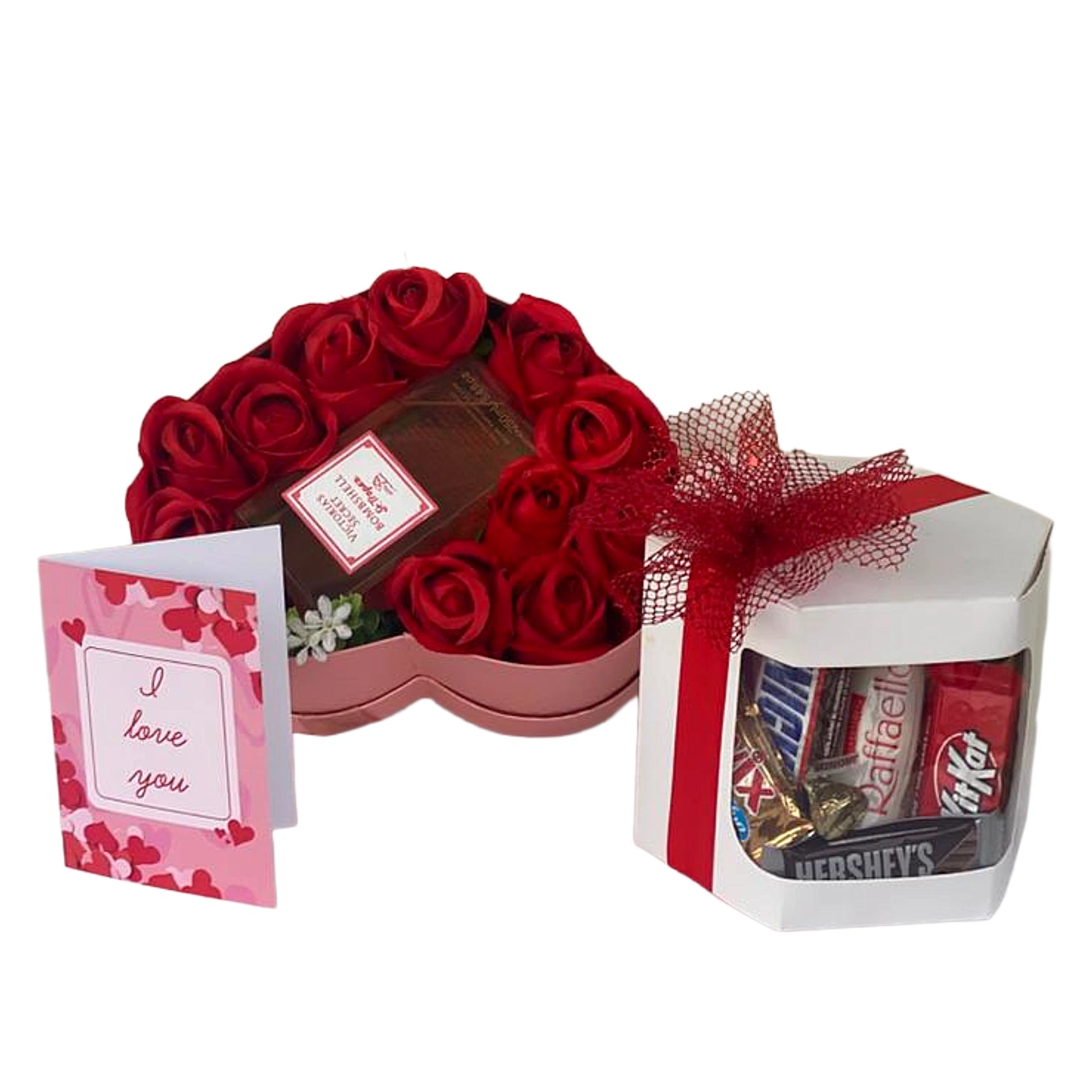Heart-shaped box of red roses with a card and a small box of candy on a white background