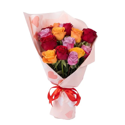 Bouquet of colorful roses wrapped in pink paper with a red ribbon on a white background