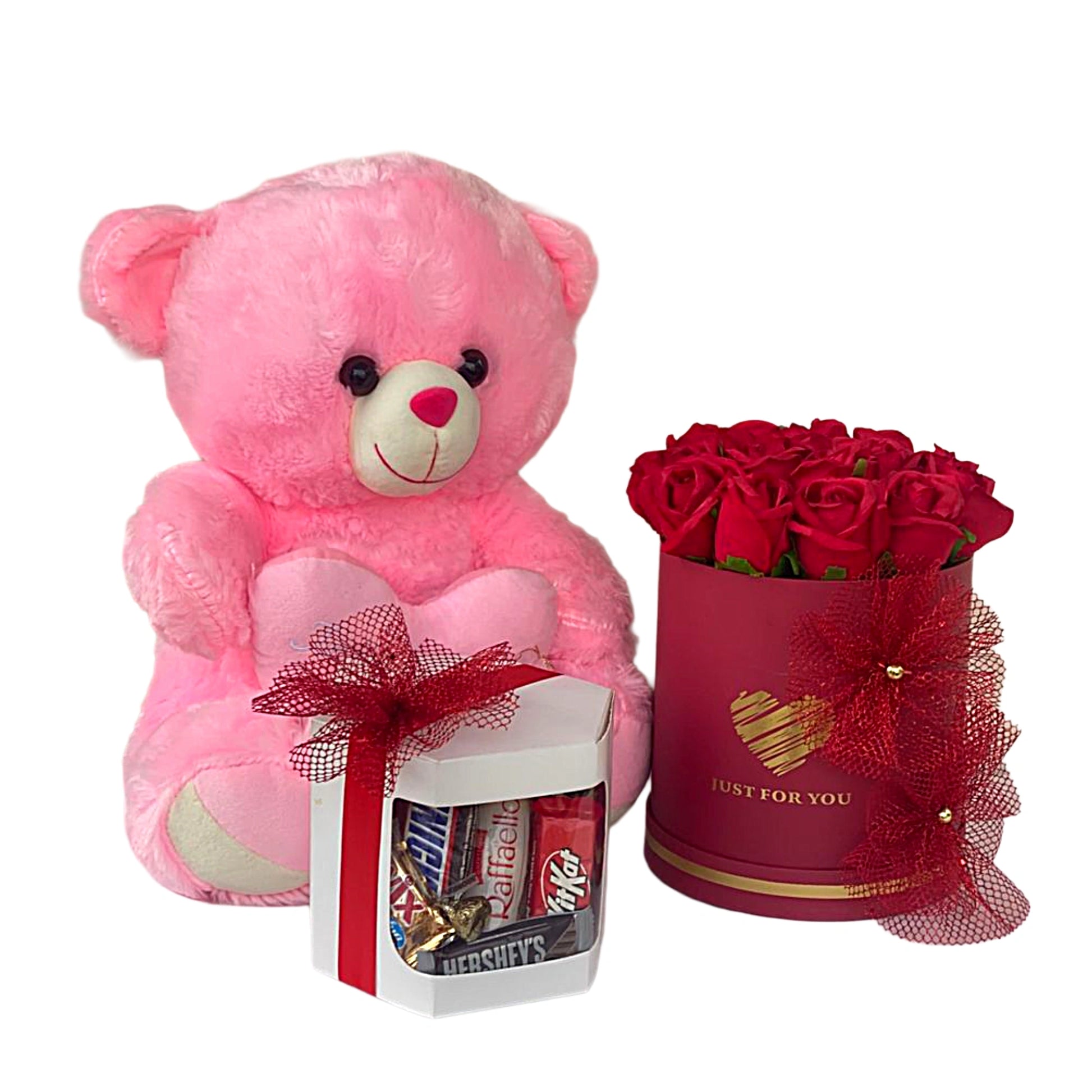 Pink teddy bear, red roses in a box, and a small gift set on a white background