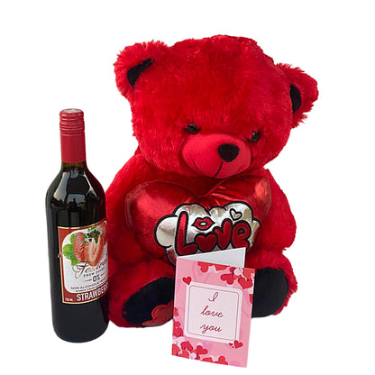 Red teddy bear with a heart-shaped 'I love you' card, bottle of strawberry-flavored wine, and a small box on a white background.